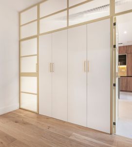 Interior design industriale: armadi bianchi con ante in ferro color crema e vetro traslucido con effetto diffuso