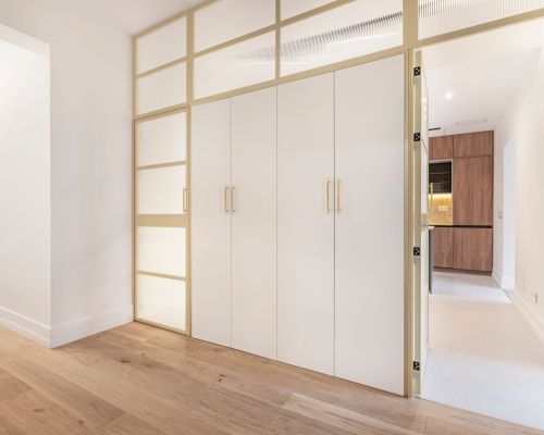 Interior design industriale: armadi bianchi con ante in ferro color crema e vetro traslucido con effetto diffuso